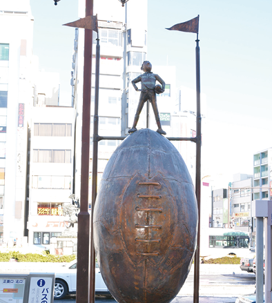 熊谷駅前にある「ラグビータウン熊谷」モニュメントのラグビーボールと少年の像