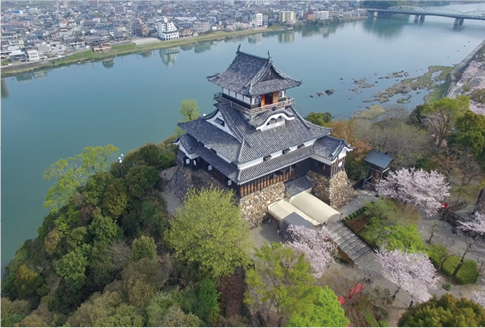 木曽川の南岸にそびえ立つ「国宝犬山城」。川の向こう側（北岸）が岐阜県、手前に本町通りを中心にした城下町が広がる