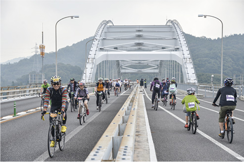 2014年10月に開催されたサイクリン グイベント「瀬戸内しまなみ海道国際 サイクリング大会」の様子。広島県と 愛媛県とが協力し、しまなみ海道の高 速道路部分(今治IC~因島北IC)を通 行止めにした。写真は伯方・大島大橋