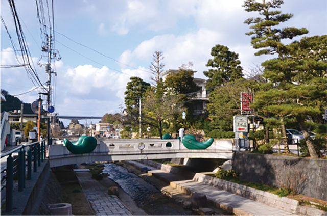 松江市玉湯町を流れる玉湯川に沿って桜の木と老舗旅館が立ち並ぶ玉造温泉街。奈良時代以前に開湯したと言われ、大国主（おおくにぬし）とともに出雲の国造りを行った 少彦名命（すくなひこなのみこと）が発見した湯と伝えられている