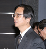 講師紹介をする奥村・大会実行委員